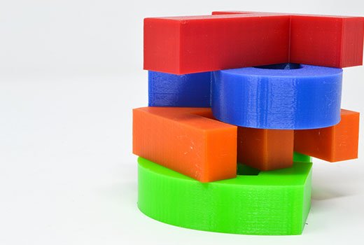 Red,blue,orange,green 3d printed parts laid atop of each other