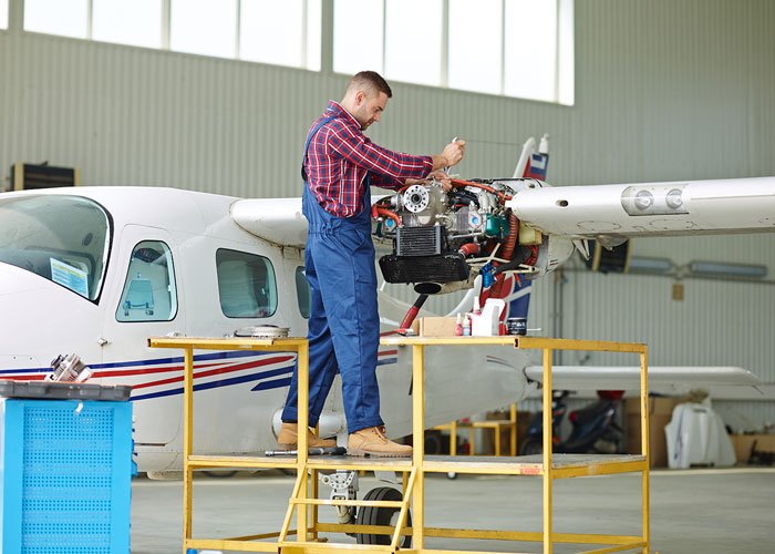 engineer conducting repairs on a plane wing