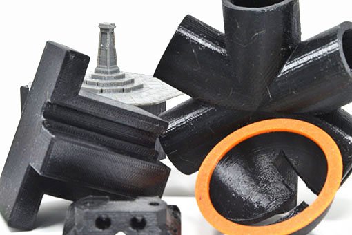 assortment of PETG parts, some black, some grey, some with orange highlights